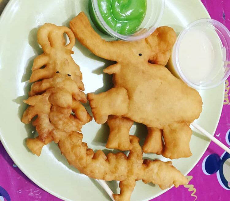 Pathongko Ko Neng  ;  The Famous Deep fried donuts  with twist- served on stick and shape like  Dragons, Dinosaurs, crocodiles and elephants with hot soy milk or hot drinking.