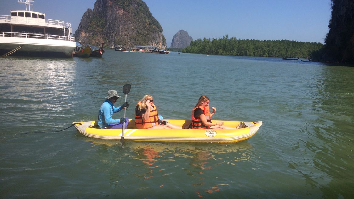 Canoe paddle around motain that has a cave for boat pass